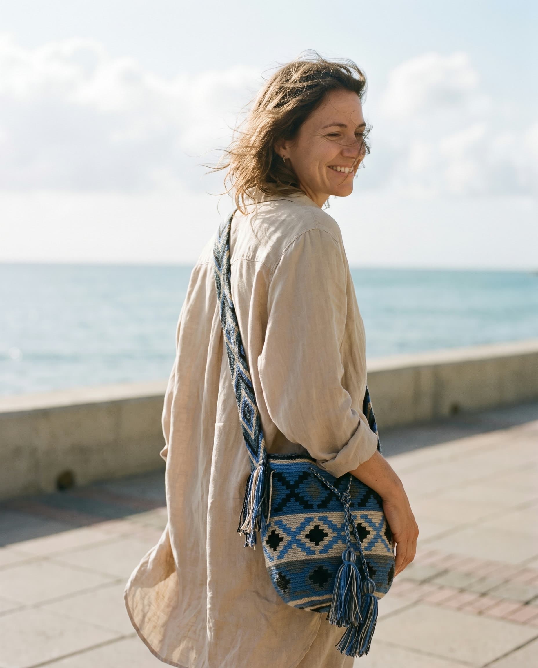 Die indigofarbene Mochila crossbody auf einer sonnigen Strandpromenade