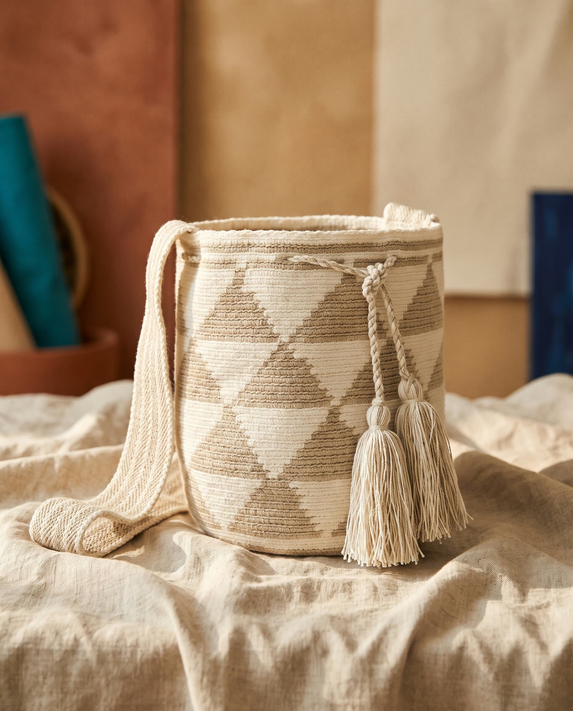 Handgewebte Wayuu-Mochila mit Rautenmuster in Creme und Topo auf Leinen