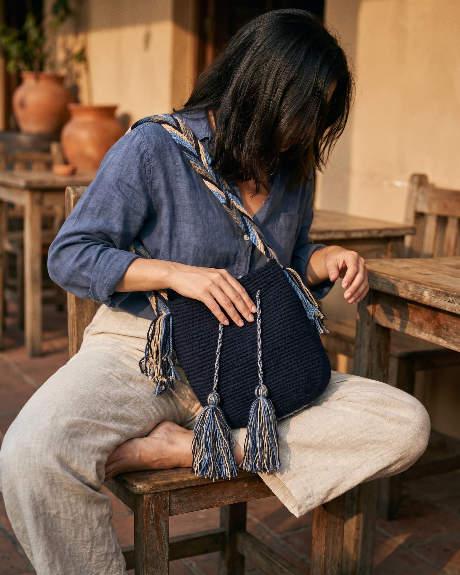 Frau mit abgewandtem Gesicht, die die marineblaue Mochila Lisa mit dem breiten Zickzack-Henkel trägt.